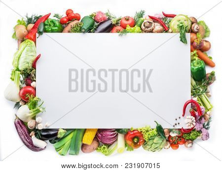 Different colorful vegetables arranged as a frame on white background. Free space for your text.