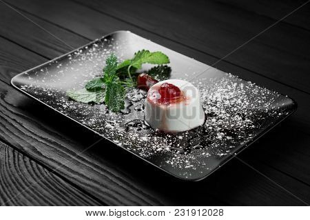Photo Of Italian Panna Cotta Dessert With Strawberry Sirup And Mint Leaf On The Black Wooden Backgro
