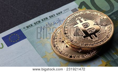 Two gold coins bitcoin stack on paper euro bill
