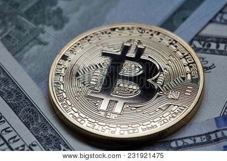 Close-up of gold coin bitcoin on dollar bills