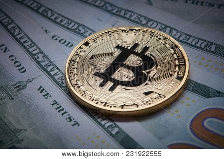 Close-up of gold bitcoin and dollars