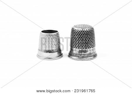 Two Metal Silver Sewing Thimbles On A White Background. Sewing Accessories And Tools