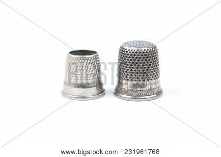 Two Metal Silver Sewing Thimbles On A White Background. Sewing Accessories And Tools