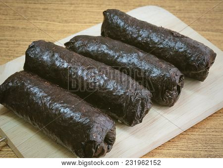 Japanese Cuisine, Traditional Unsliced Japanese Rice Maki Sushi Roll With Nori Seaweed On Cutting Bo