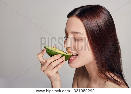 Tender Brown-haired Lady Eating Avocado