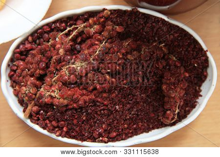 Dried Sumac Seasoning In A Wooden Bowl, Top View. A Handful Of Red Sumac Powder In A Plate Abstract 