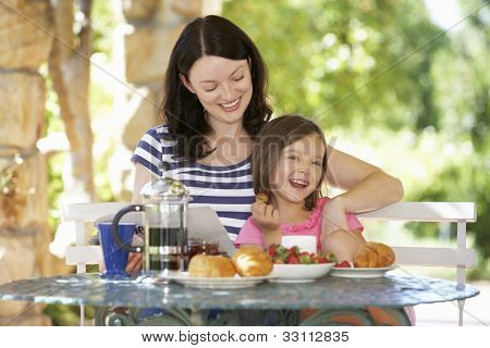 Mère et fille manger le petit déjeuner à l'extérieur