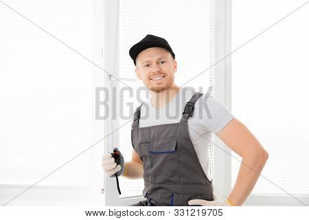 Master Worker Looking Camera And Smiling Measures Upvc Window With Ruler, Installation Process