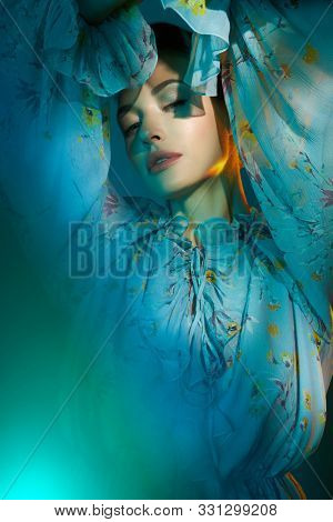 Fashion studio photo of young beautiful lady in blue chiffon dress on multi-colored background. Fashion and style. Fashion look book
