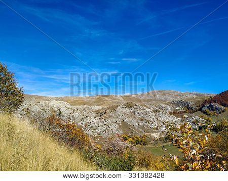 Rocky Deserted Mountain Bjelasnica In Dinaric Alps During Autumn With Yellow Grass, Trees And Grey R