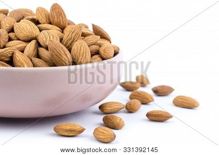 Almonds In Pink Porcelain Bowl On White Background.close Up