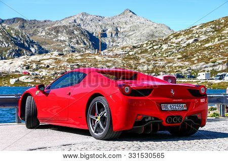 Saint Gotthard Pass, Switzerland - September 13, 2019: Red Supercar Ferrari 458 Italia At The Backgr