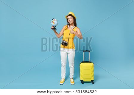 Traveler Tourist Woman In Yellow Casual Clothes, Hat With Suitcase Photo Camera Isolated On Blue Bac