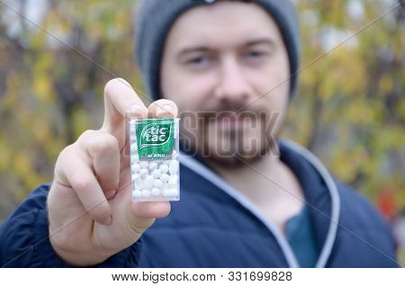 Kharkov, Ukraine - October 26, 2019: Young Man Shows New Tic Tac Hard Mints Package In Autumn Park. 