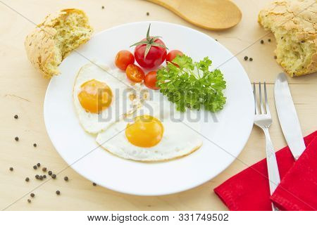 Fried Eggs On A Plate On Rustic Wooden Background