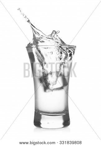 Ice Cube Falling Into Shot Glass Of Vodka On White Background