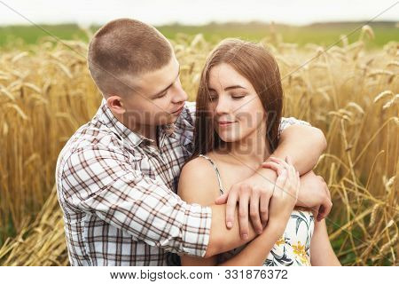 Young Couple In Love In A Wheat Field. Man And Girl Hugging In Nature, Close-up