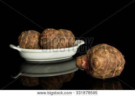 Group Of Four Whole Fresh Brown Jerusalem Artichoke In White Oval Ceramic Bowl Isolated On Black Gla