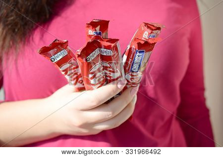 Kharkov, Ukraine - October 21, 2019: A Young Caucasian Brunette Girl Holds Many Kit Kat Chocolate Ba