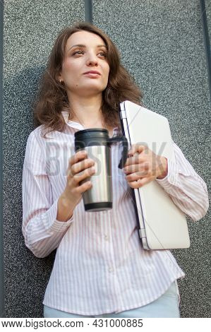 Female Portrait Of Young Woman With Silver Laptop And Cup Of Coffee Waiting For A Meeting Near Dark 