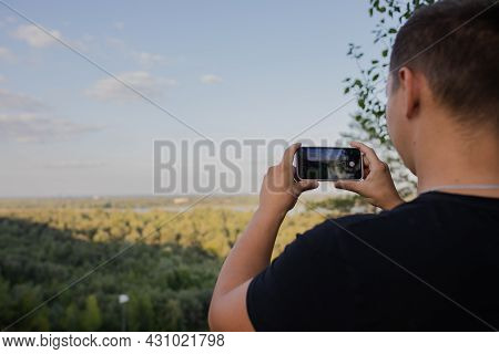 A Man Takes Pictures Of Nature On A Mobile Phone. View From Behind. Selektiv Focus. Russia, Altai Te