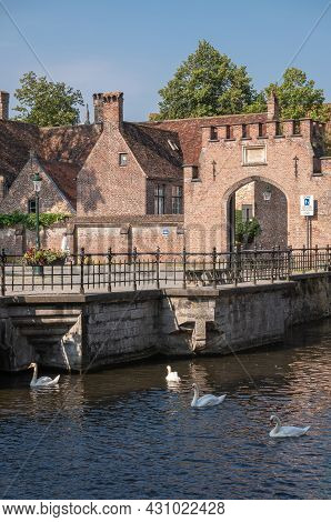 Brugge, Flanders, Belgium - August 4, 2021: Sunlit Red Brick Back Entrance To Housing Area Within Be