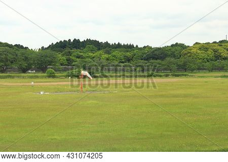 Wind Sock Pole Comprised Of Red And White Bands, Used To Determine The Wind Direction And Speed.
