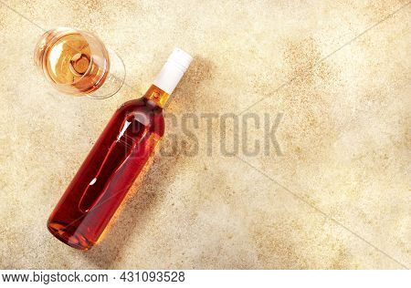 Rose Wine Glass With Bottle On The Beige Table. Copy Space, Top View