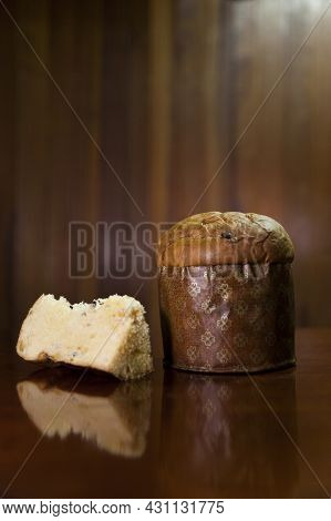 Panettone Slice On The Table. Panettone Cut On Wooden Table And Textured Background. Panettone Conce