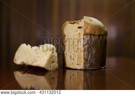 Panettone Slice On The Table. Panettone Cut On Wooden Table And Textured Background. Panettone Conce