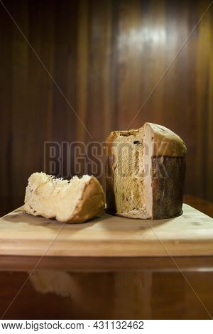 Panettone Slice On The Table. Panettone Cut On Wooden Table And Textured Background. Panettone Conce