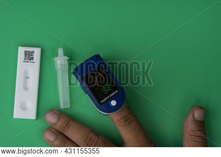The Covid 19 Rapid Antigen Test Kit And Oxymeter Taking The Reading. Selective Focus Points.