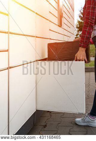 Pickup Parcel. Courier Box In Woman Hands At Post Delivery Automat Terminal. Self Service Post Termi