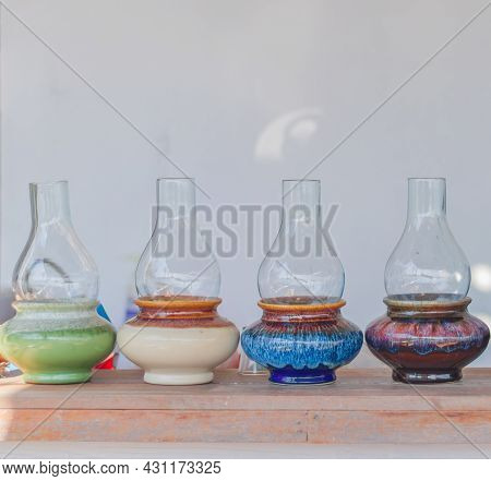 Handmade Green, Light Brown, Blue And Purple Jars Line The Counter.