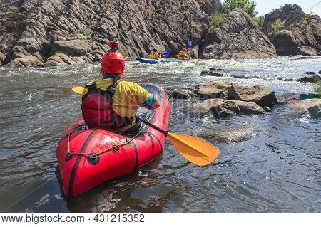A Woman Rowing Inflatable Packraft On Whitewater Of Mountain River. Concept: Summer Extreme Water Sp