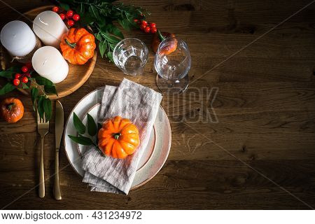 Autumn Table Setting With Plate, Pumpkin And Candles.