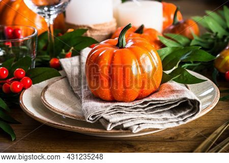 Autumn Table Setting With Plate, Pumpkin And Candles.