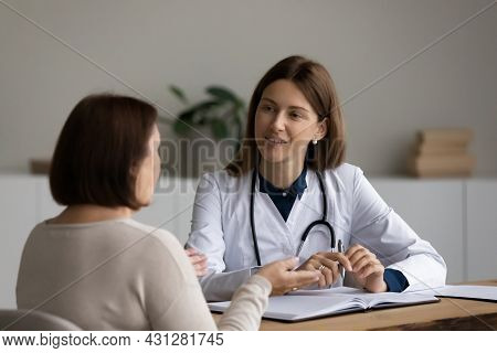 Happy Young Gp Doctor Examining Older Patient.
