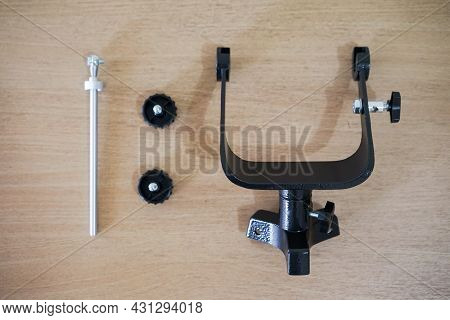 Yoke Altazimuth Mount, Thumb Screw, And Vertical Fine Adjustment Rod. Telescope Parts On Wooden Tabl