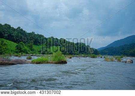 Riverscape Photography- River Flowing Under Blue Sky, Forest And Mountains Between A Cloudy Sky And 