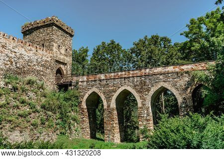 Gate And Bridge To Bitov Castle On Steep Promontory Towering Above Meandering River Zeletavka,czech 