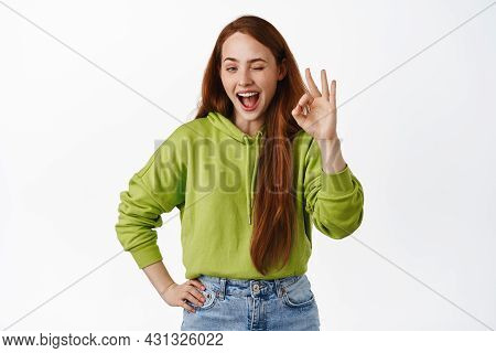 Portrait Of Redhead Girl Assure All Okay, No Proble, Say Yes And Winking, Showing Zero Ok Gesture, S