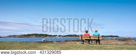Vedettes De Bréhat, France, 10 August 2021: Couple On Bench Looks At Ferry To Ile De Brehat In Frenc