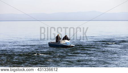 Two Men Are Fishing From  Boat At The Confluence Of The River In Lake Baikal. Landscape With   Boat 