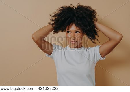 Feeling Gorgeous. Portrait Of Young Attractive Sensual African Woman Touching With Hands Her Curly H