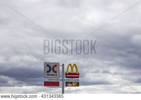 View Of Logotype Board Of Well-known Gas Station Okq8 And Mcdonald's Logotype Board On White Clouds 