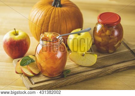 Fresh Homemade Pumpkin Apple Marmalade Jam In Glass Jar On A Wooden Background. Several Fresh Apples