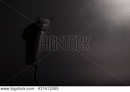 Simple Black Microphone Close Up On Black Background With Cooy Space.