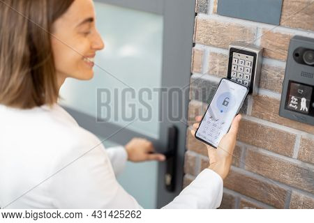 Woman Puts The Smart Phone To The Electronic Reader To Access The Apartment Or Office. Cell With Run