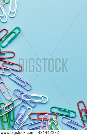 Multicolored Paper Clips On A Blue Background.